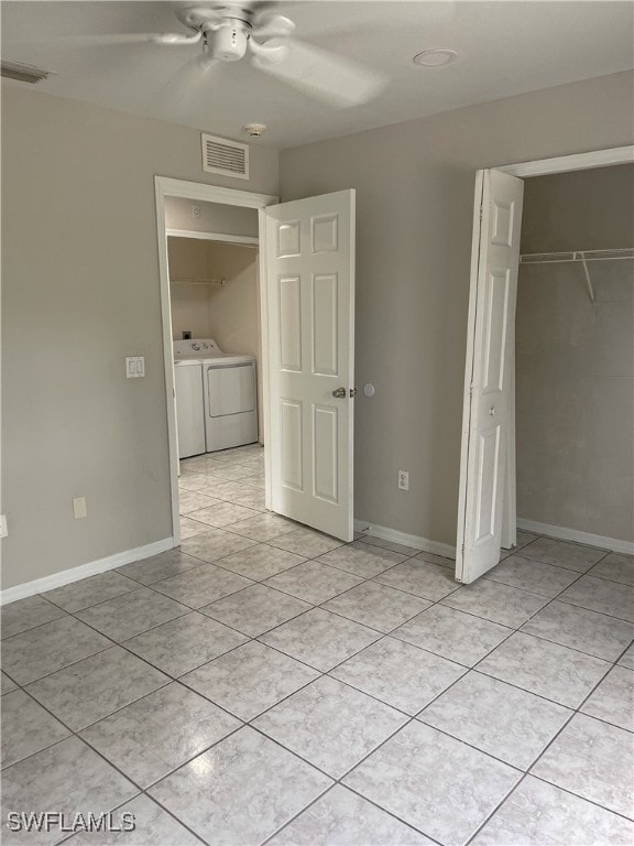 unfurnished bedroom with a closet, light tile patterned flooring, washer and clothes dryer, and ceiling fan