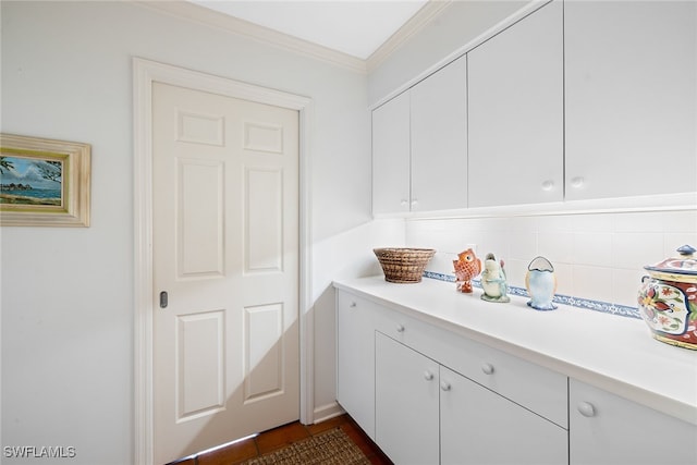 interior space featuring tasteful backsplash, white cabinetry, and crown molding