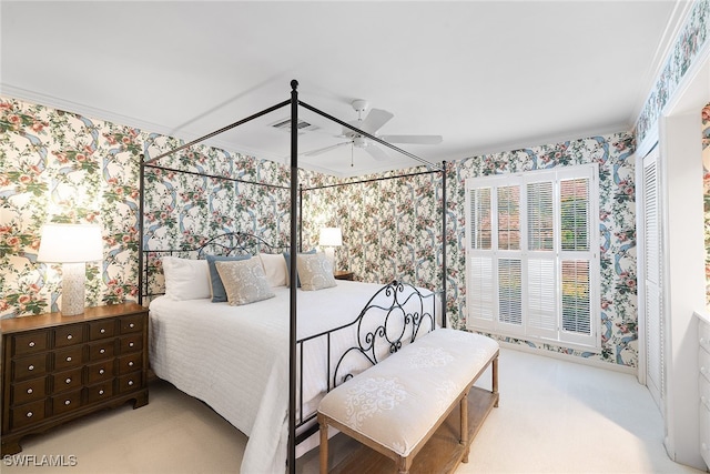 carpeted bedroom with a closet, ceiling fan, and crown molding