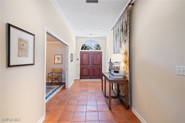 entryway with ornamental molding and light tile patterned flooring