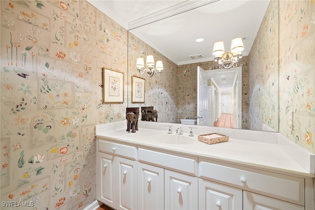 bathroom featuring vanity, toilet, ornamental molding, and a chandelier