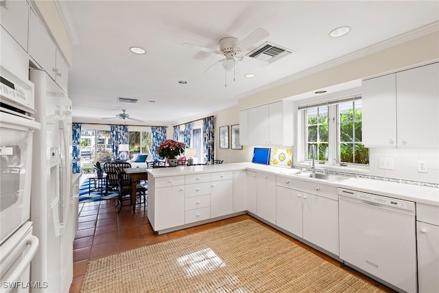 kitchen featuring kitchen peninsula, white appliances, tasteful backsplash, and white cabinetry