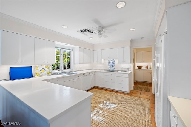 kitchen featuring white cabinets, white dishwasher, kitchen peninsula, and sink