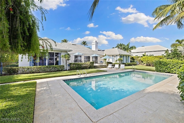 view of pool with a lawn