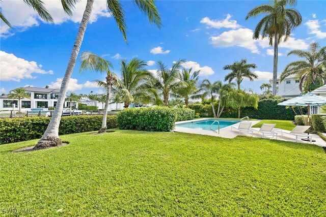 3323 Gin Ln, Naples, FL 34102 - view of green lawn with an outdoor pool and a patio area