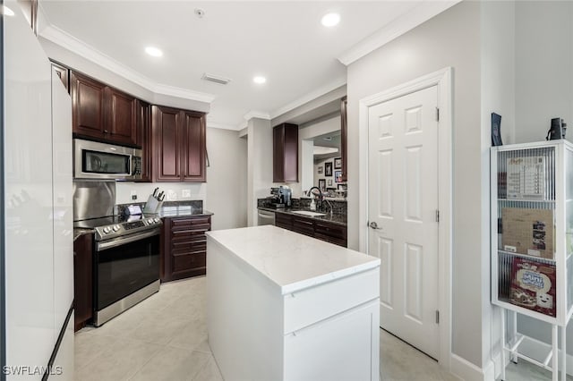 kitchen featuring light tile patterned flooring, sink, appliances with stainless steel finishes, ornamental molding, and a center island