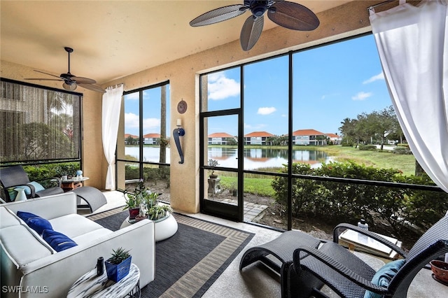 sunroom / solarium featuring ceiling fan and a water view