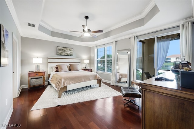 bedroom featuring dark wood-style floors, a tray ceiling, visible vents, ornamental molding, and access to outside