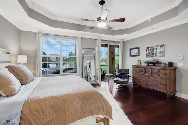 bedroom featuring ceiling fan, dark hardwood / wood-style floors, a tray ceiling, and ornamental molding