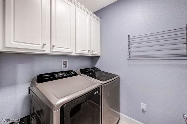 laundry room featuring cabinets and washer and clothes dryer