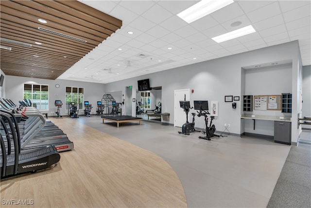 workout area featuring a drop ceiling and light wood-type flooring