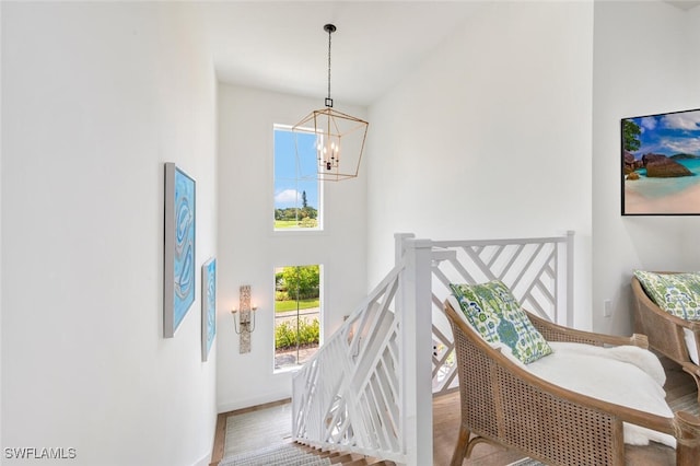 stairs with a chandelier and hardwood / wood-style flooring