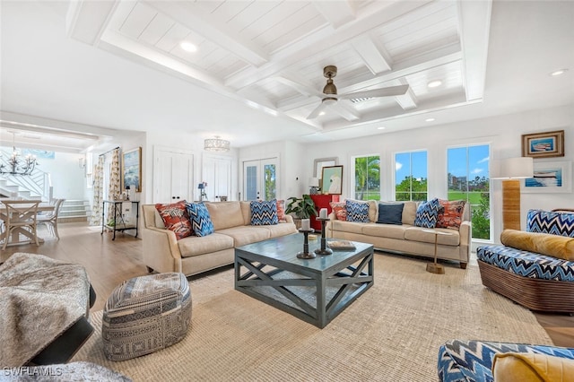 living room featuring light hardwood / wood-style floors, beam ceiling, coffered ceiling, and ceiling fan with notable chandelier