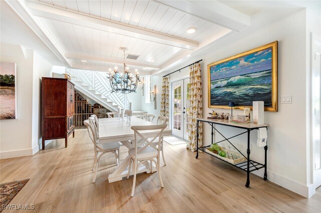 dining space featuring beam ceiling, a chandelier, light hardwood / wood-style flooring, and wood ceiling