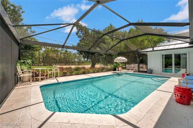 view of pool with a patio area and glass enclosure