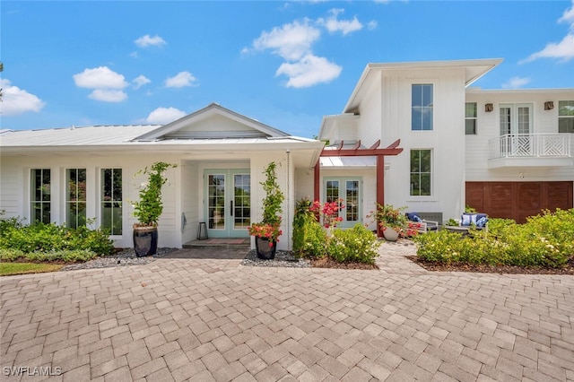 back of property with a balcony and french doors