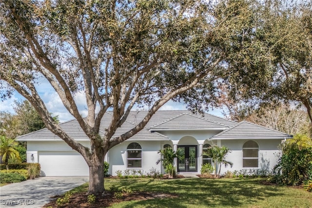 ranch-style home with a garage and a front lawn