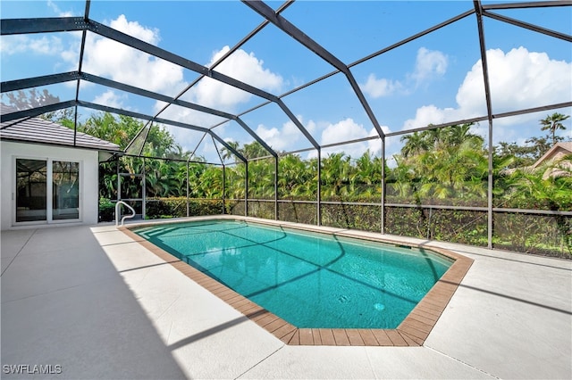 view of swimming pool featuring a patio area and glass enclosure