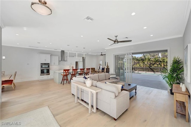 living room featuring ornamental molding, ceiling fan, and light hardwood / wood-style flooring