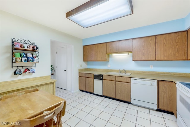 kitchen featuring sink, white appliances, and light tile patterned flooring