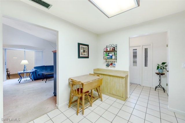 kitchen with lofted ceiling and light carpet