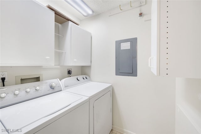 clothes washing area featuring electric panel, washing machine and dryer, cabinets, and a textured ceiling