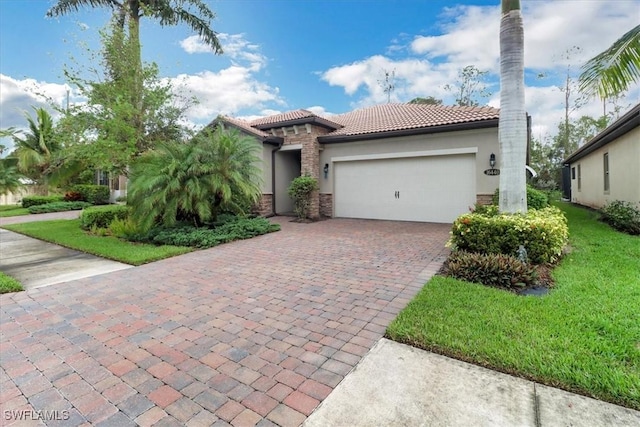 mediterranean / spanish home featuring a garage and a front yard