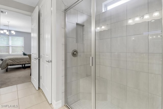 bathroom featuring tile patterned flooring, a notable chandelier, and a shower with shower door