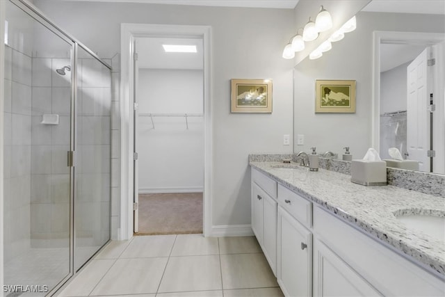 bathroom with walk in shower, vanity, and tile patterned flooring