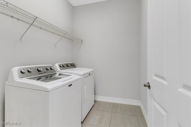 clothes washing area featuring separate washer and dryer and light tile patterned floors