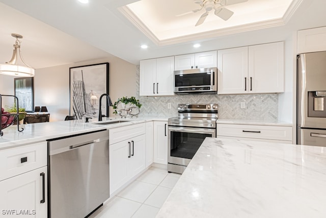 kitchen with white cabinetry, appliances with stainless steel finishes, a raised ceiling, pendant lighting, and sink