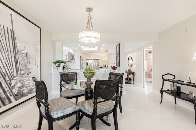 tiled dining space with a chandelier