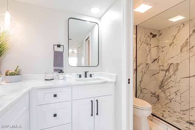 bathroom featuring toilet, vanity, and a tile shower