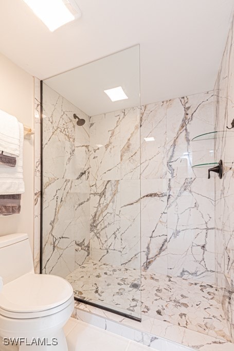 bathroom with toilet and a tile shower