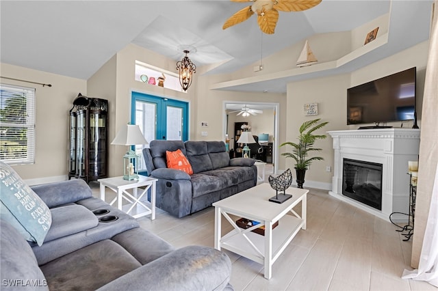 living room with french doors, ceiling fan, lofted ceiling, and light wood-type flooring