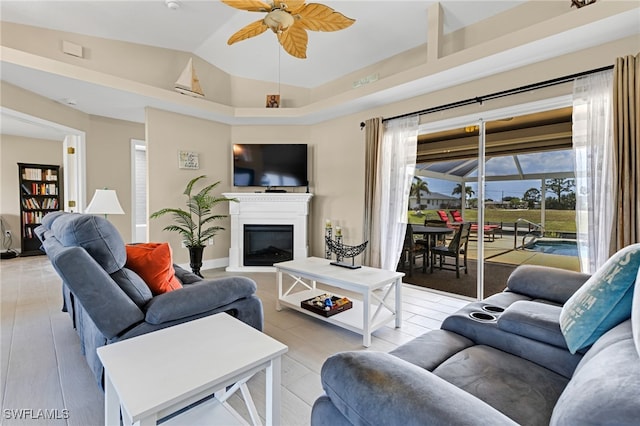 living room featuring vaulted ceiling, light wood-type flooring, and ceiling fan