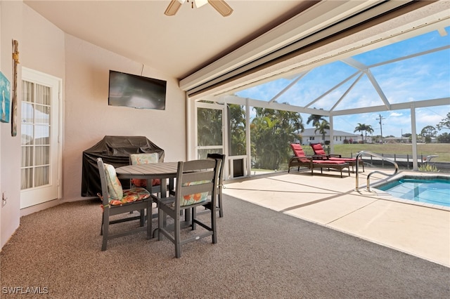 view of patio featuring ceiling fan, grilling area, and glass enclosure