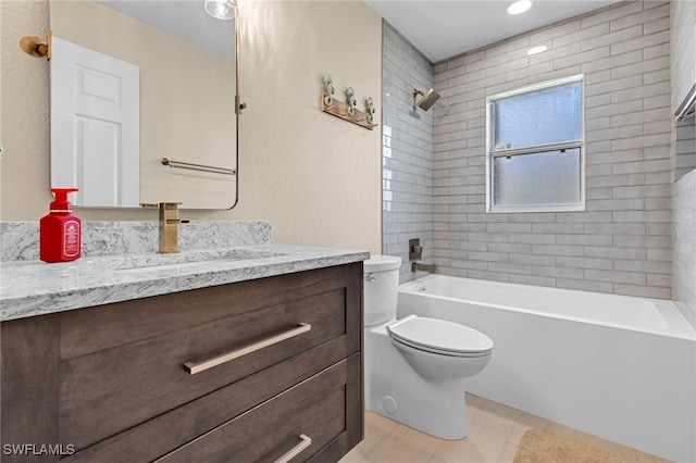 full bathroom featuring tiled shower / bath, vanity, and toilet