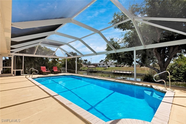 view of swimming pool with a patio, a water view, and glass enclosure