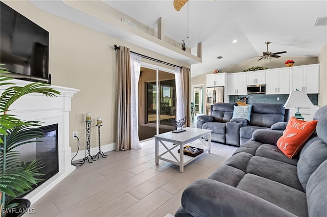 living room with light hardwood / wood-style flooring, high vaulted ceiling, and ceiling fan