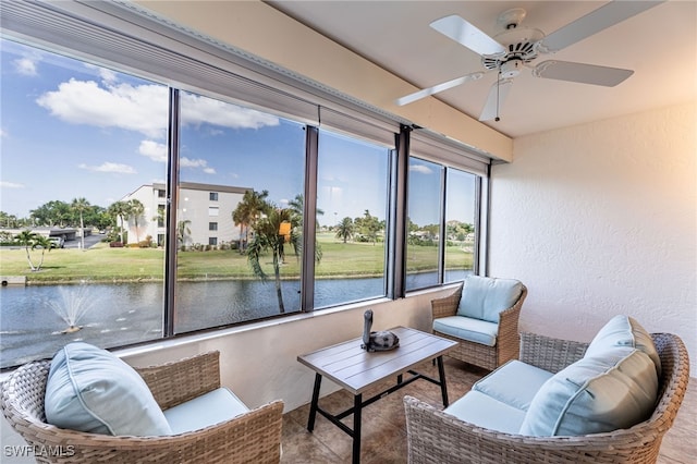 sunroom with a water view and ceiling fan