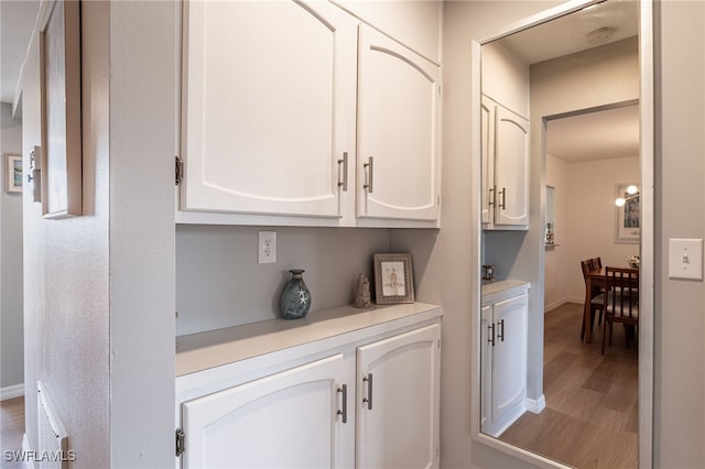 interior space featuring hardwood / wood-style floors and white cabinetry