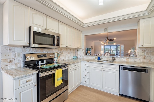 kitchen with white cabinets, light wood-type flooring, stainless steel appliances, and sink