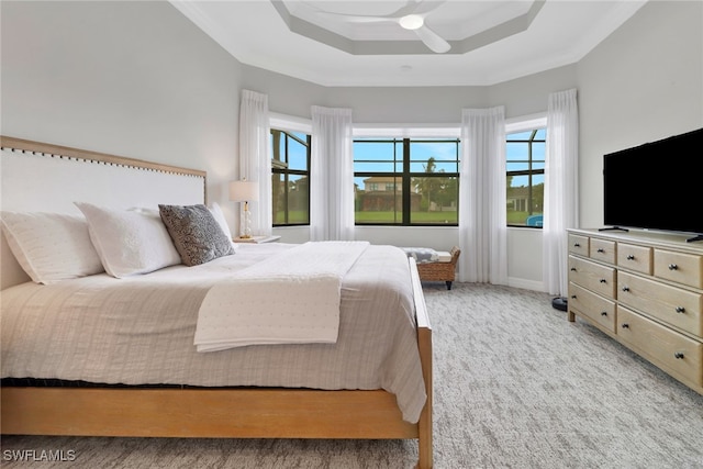 bedroom featuring ceiling fan, light colored carpet, a tray ceiling, and crown molding