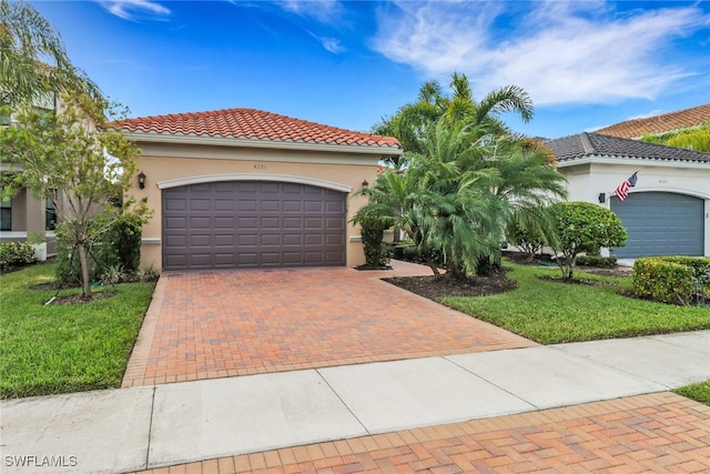 mediterranean / spanish-style home featuring a garage and a front yard