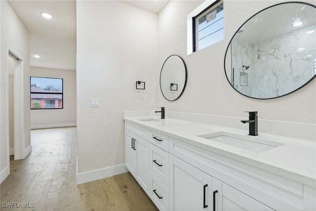 bathroom with vanity, hardwood / wood-style floors, a shower, and plenty of natural light