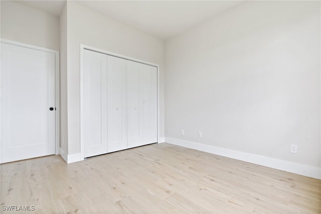 unfurnished bedroom featuring a closet and light hardwood / wood-style floors