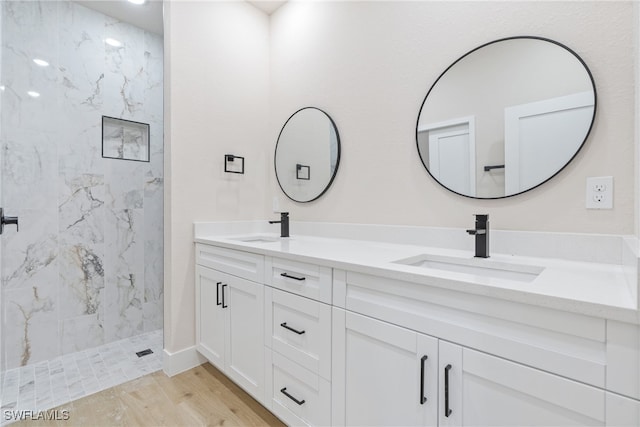 bathroom with vanity, hardwood / wood-style floors, and tiled shower