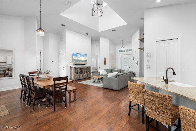 dining area featuring dark hardwood / wood-style floors, high vaulted ceiling, and sink