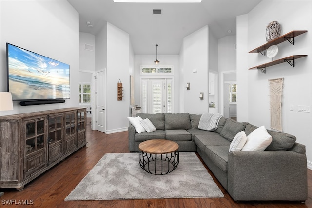 living room with high vaulted ceiling, dark wood-type flooring, and a wealth of natural light